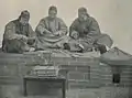 A group of Qing dynasty-era qiánpù stringing cash coins together in 1899.