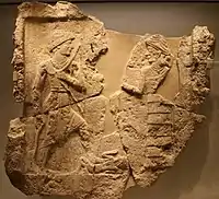 King Iddi(n)-Sin of the Kingdom of Simurrum, holding an axe and a bow, trampling a foe, facing Ishtar. Circa 2000 BCE. Israel Museum.